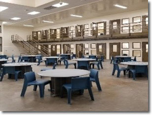 Dorm style room with tables and chairs inside the 512 jail facility